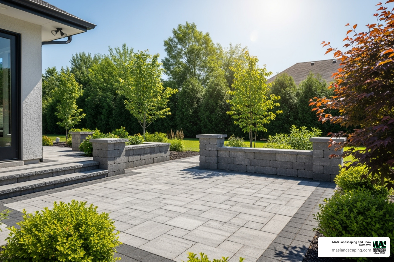 A modern patio using large format concrete pavers and a matching block wall - brick and masonry