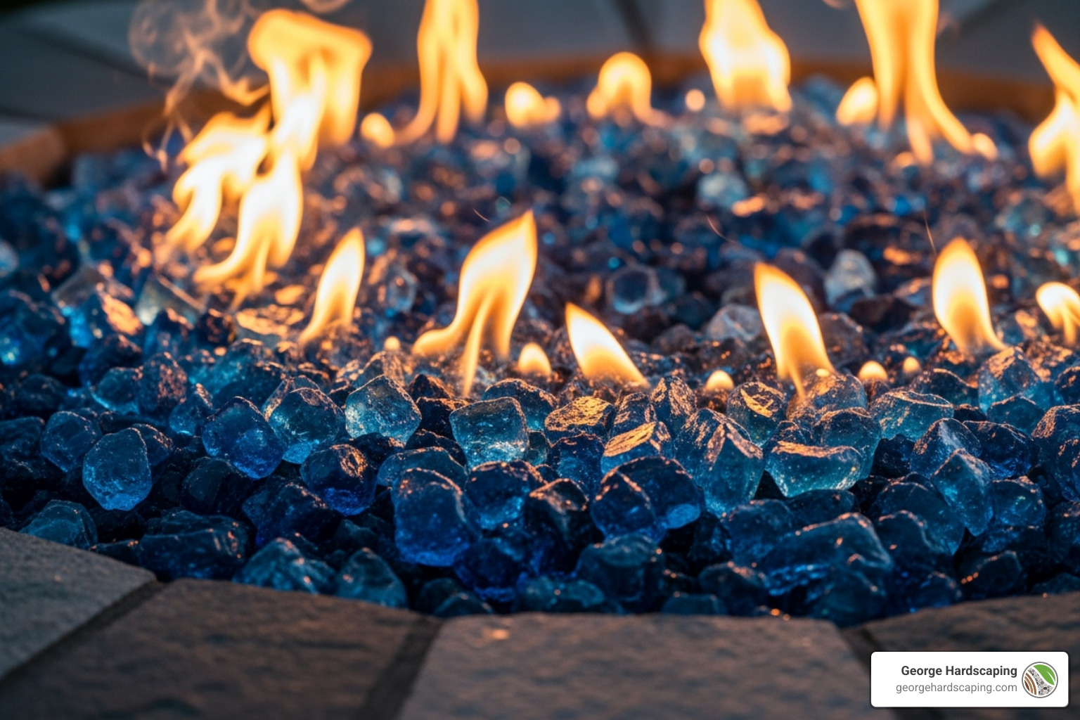 Close-up of reflective blue fire glass in a lit outdoor fire pit. - gas fireplace outdoor