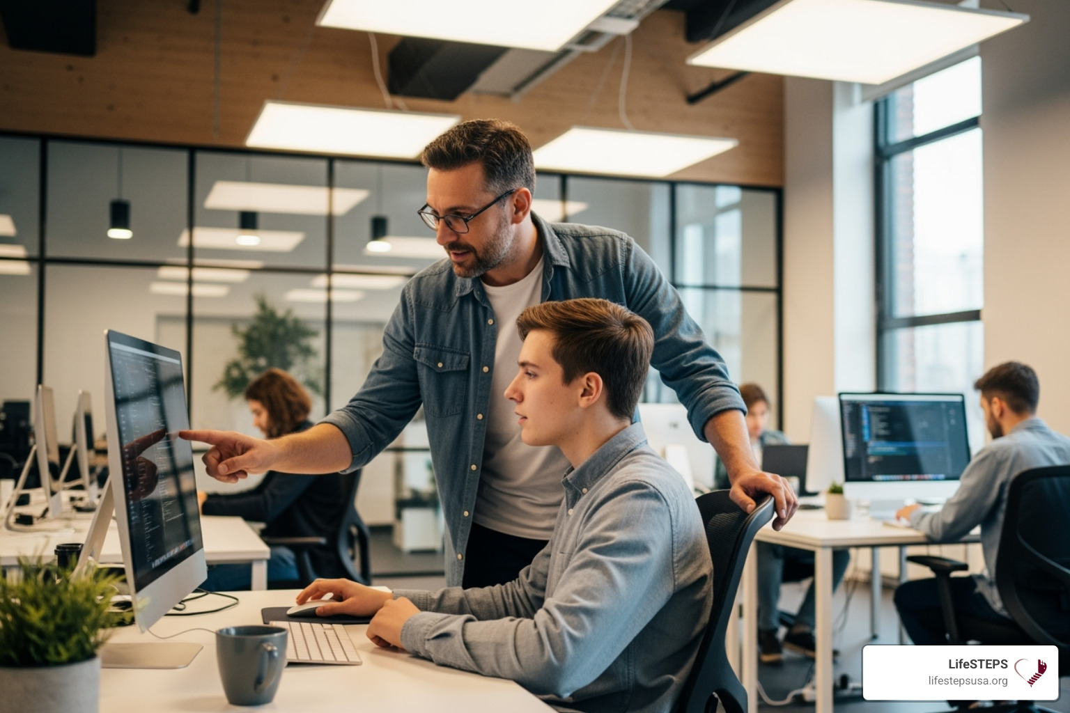 IMAGE of a mentor guiding a young person at a computer - youth workforce development programs