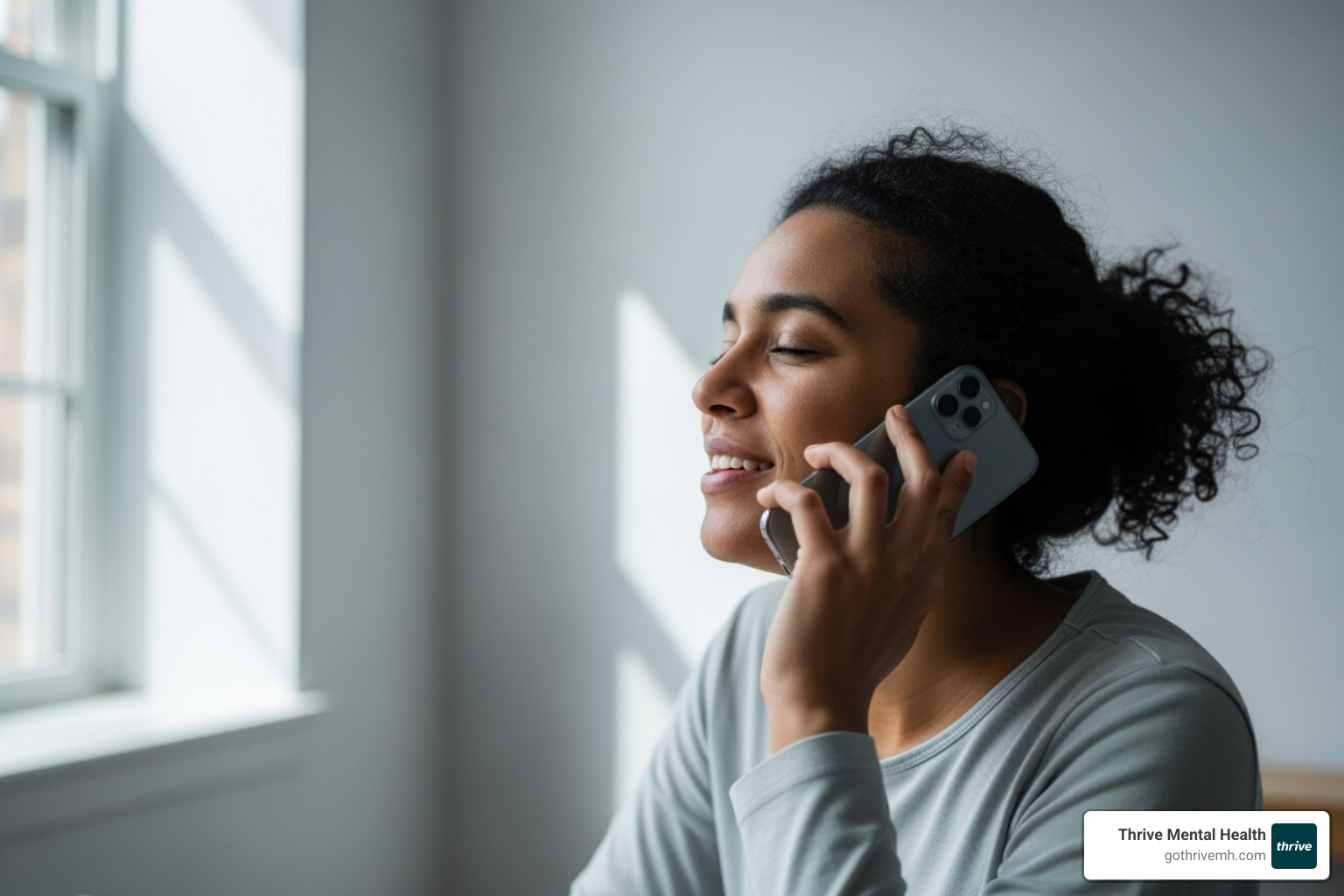 A person on a phone call, looking relieved, discussing insurance verification - telehealth IOP program