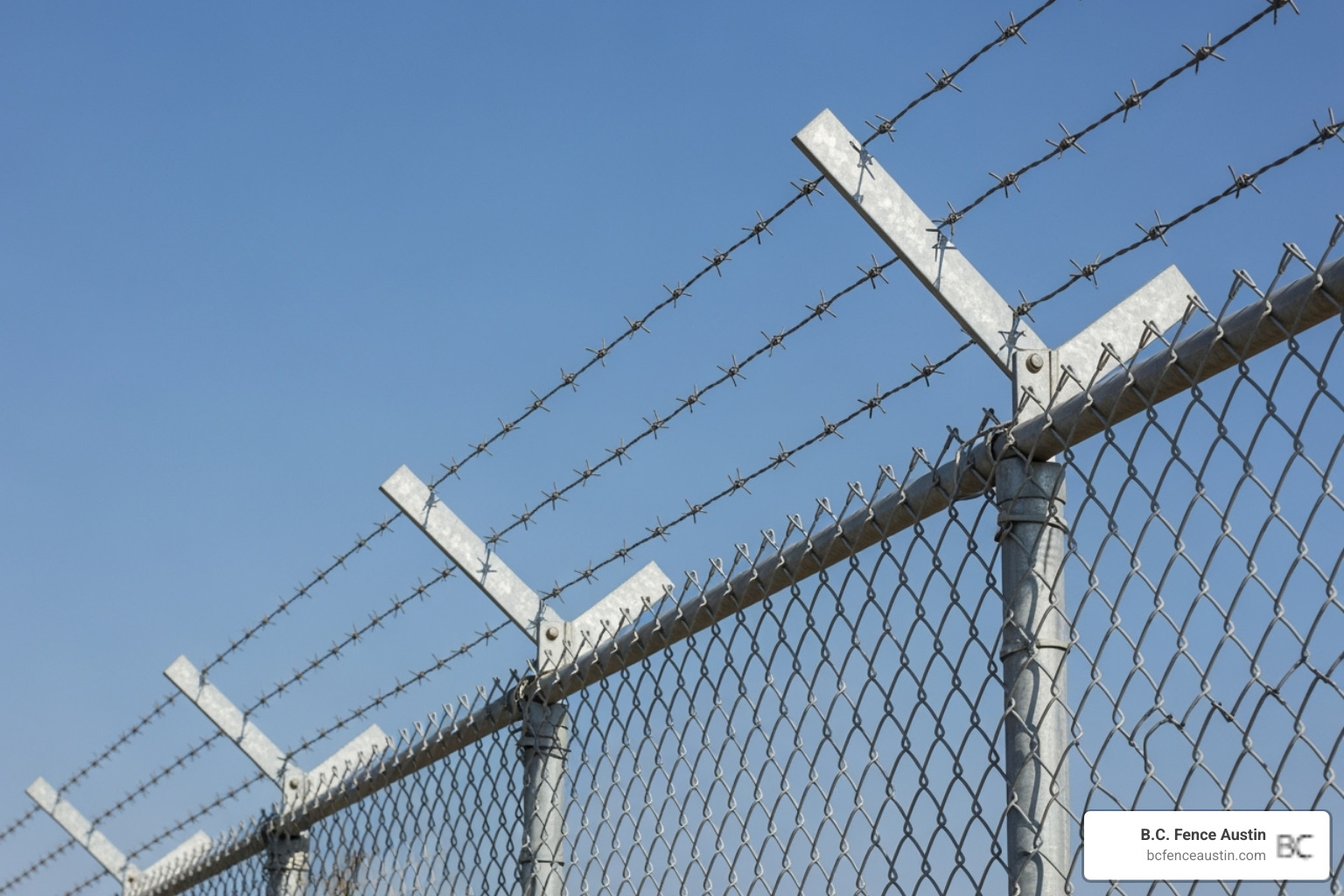 chain link fence with three strands of barbed wire on angled arms - Chain link security fence