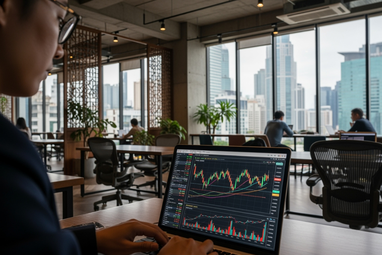 person working on a laptop in a modern co-working space in Asia, with stock charts visible on the screen - ftasiastock business news