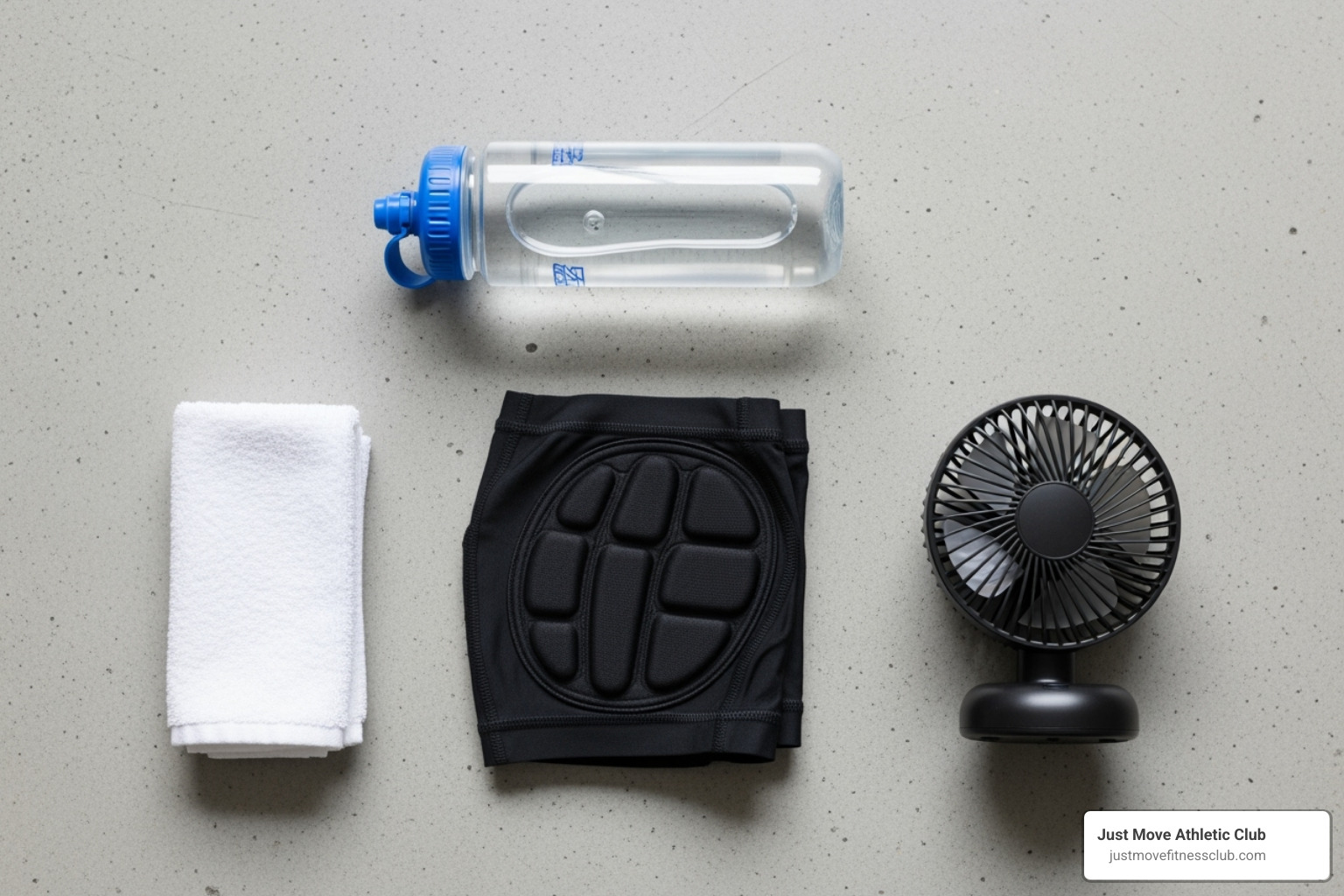 Essential indoor cycling gear laid out: water bottle, towel, padded shorts, and a fan - Indoor cycling for beginners