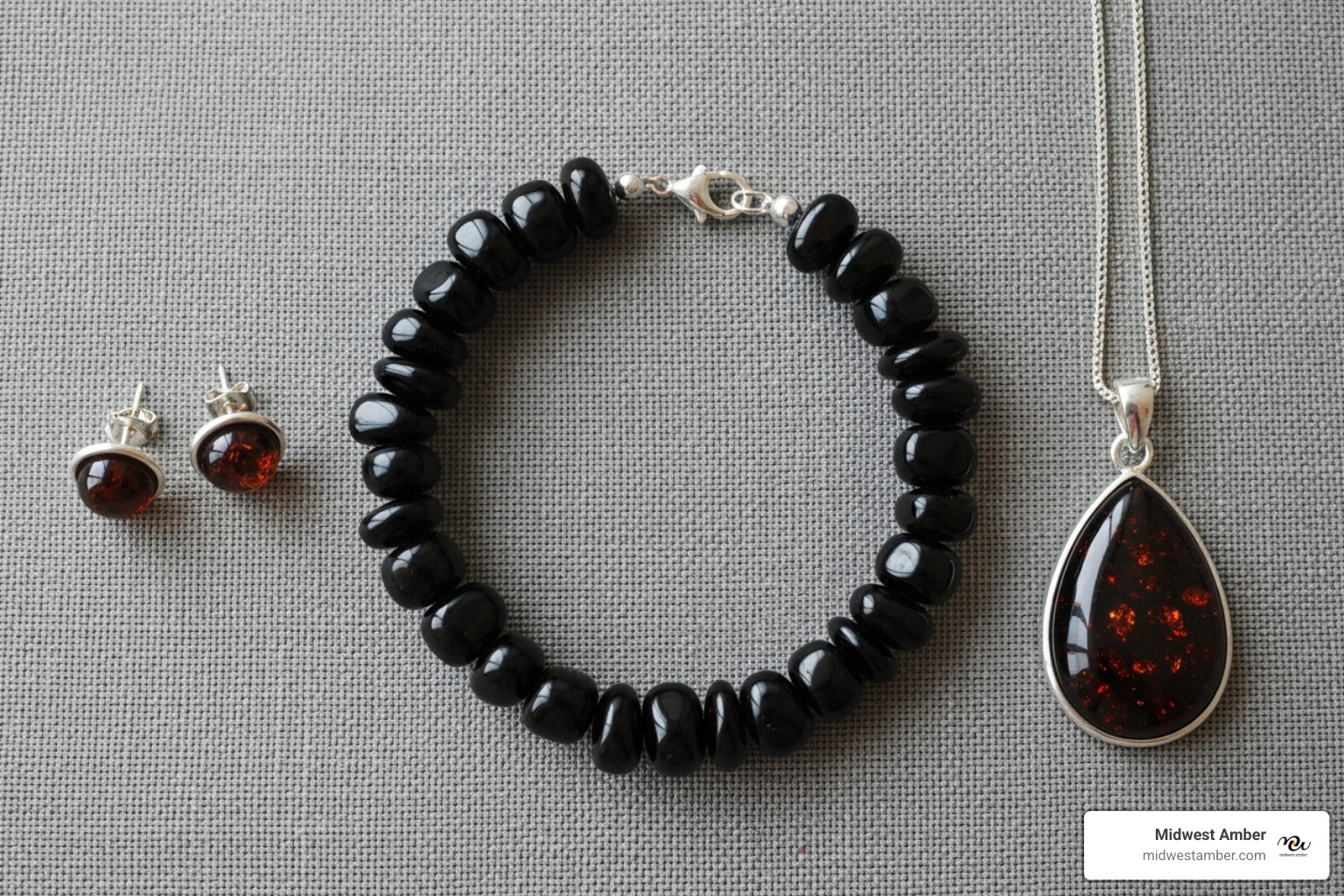 A flat lay featuring a black amber bracelet, earrings, and a pendant - black amber jewelry
