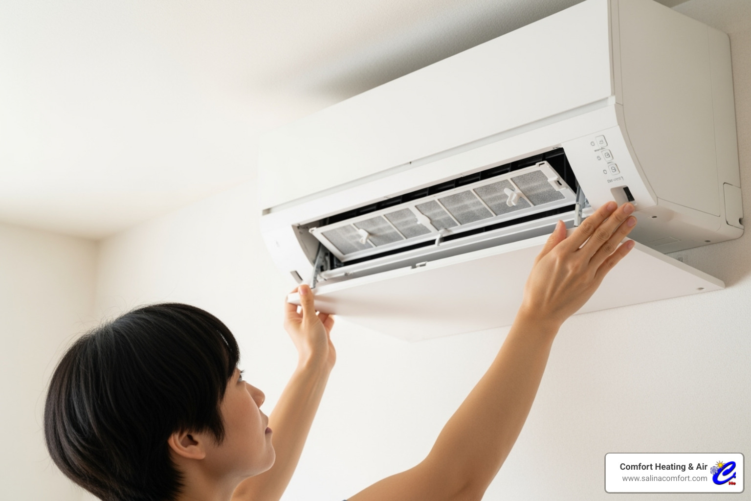 A person opening the front panel of an indoor ductless AC unit to remove and clean the air filter - ductless ac installation salina ks