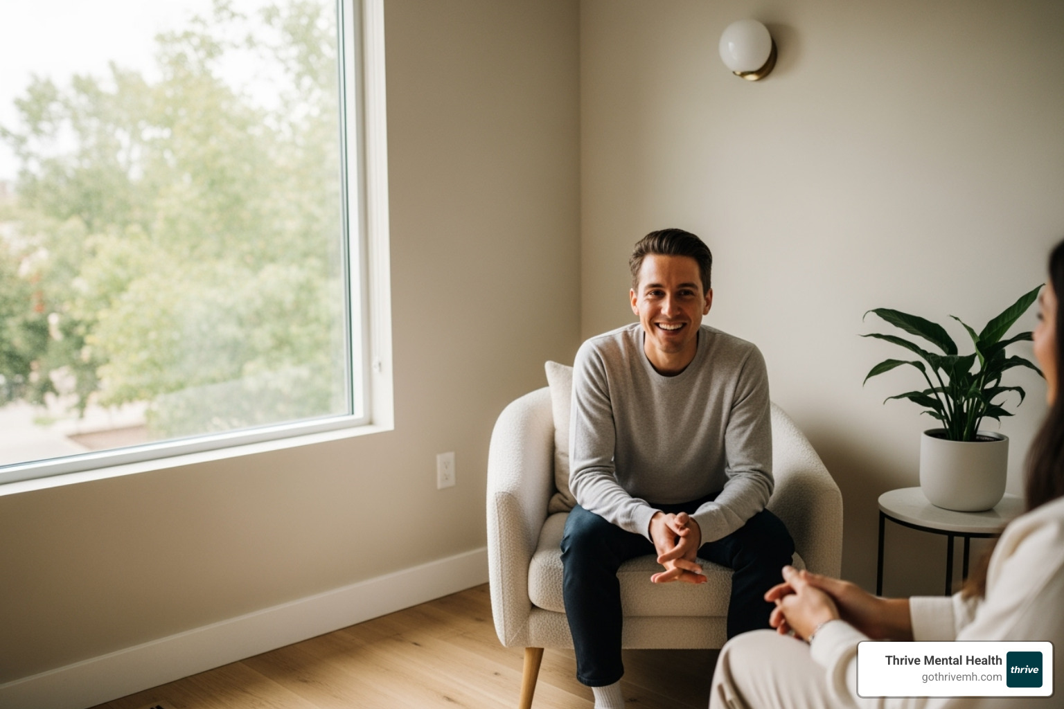 A person sitting comfortably in a modern, calm therapy office, looking relaxed and engaged with their therapist (out of frame). The setting emphasizes warmth and safety. - emdr therapist