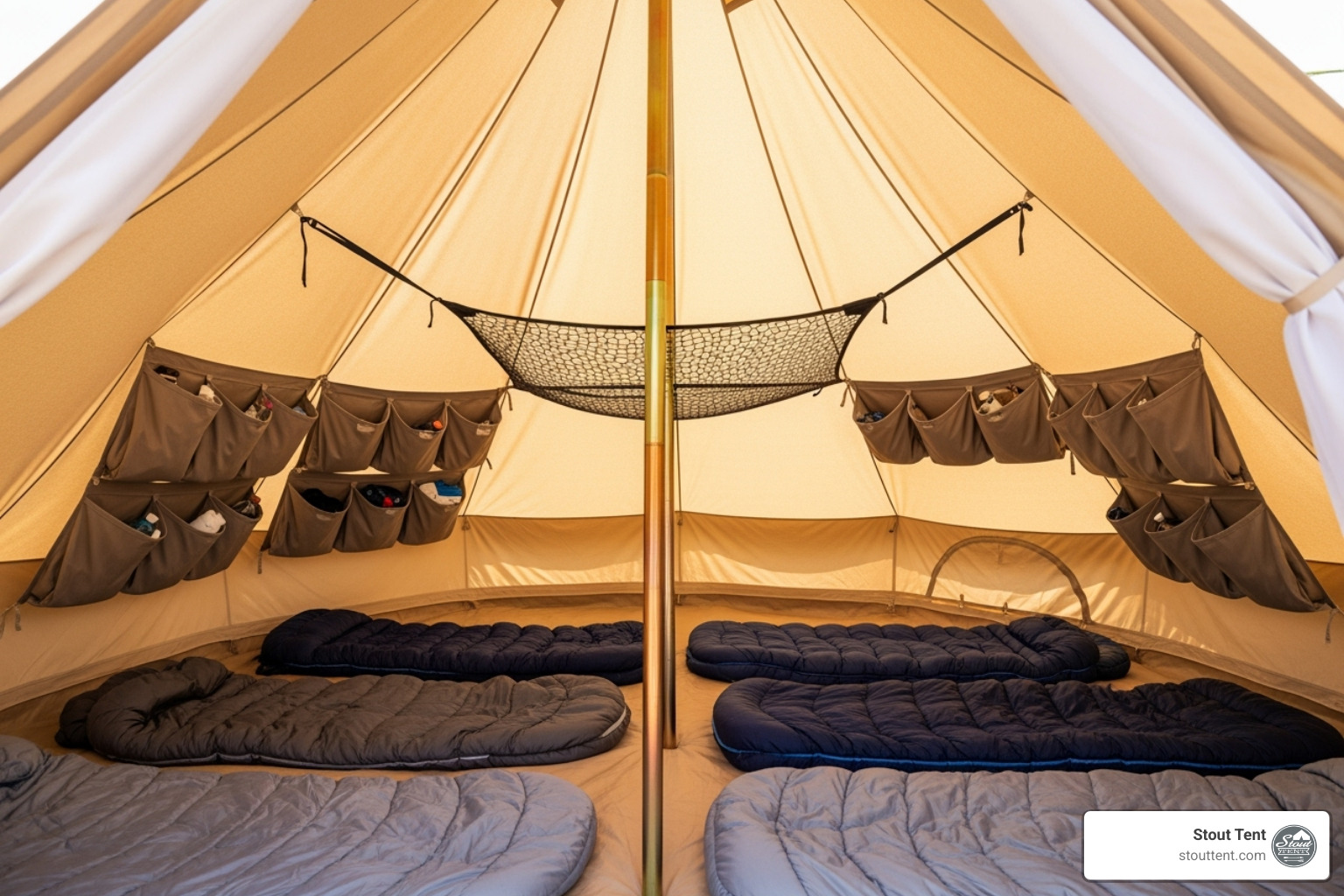 A pristine canvas bell tent interior, impeccably organized with hanging storage pockets, a gear loft, and neatly arranged sleeping bags, showcasing efficient use of space. - Camping tent accessories