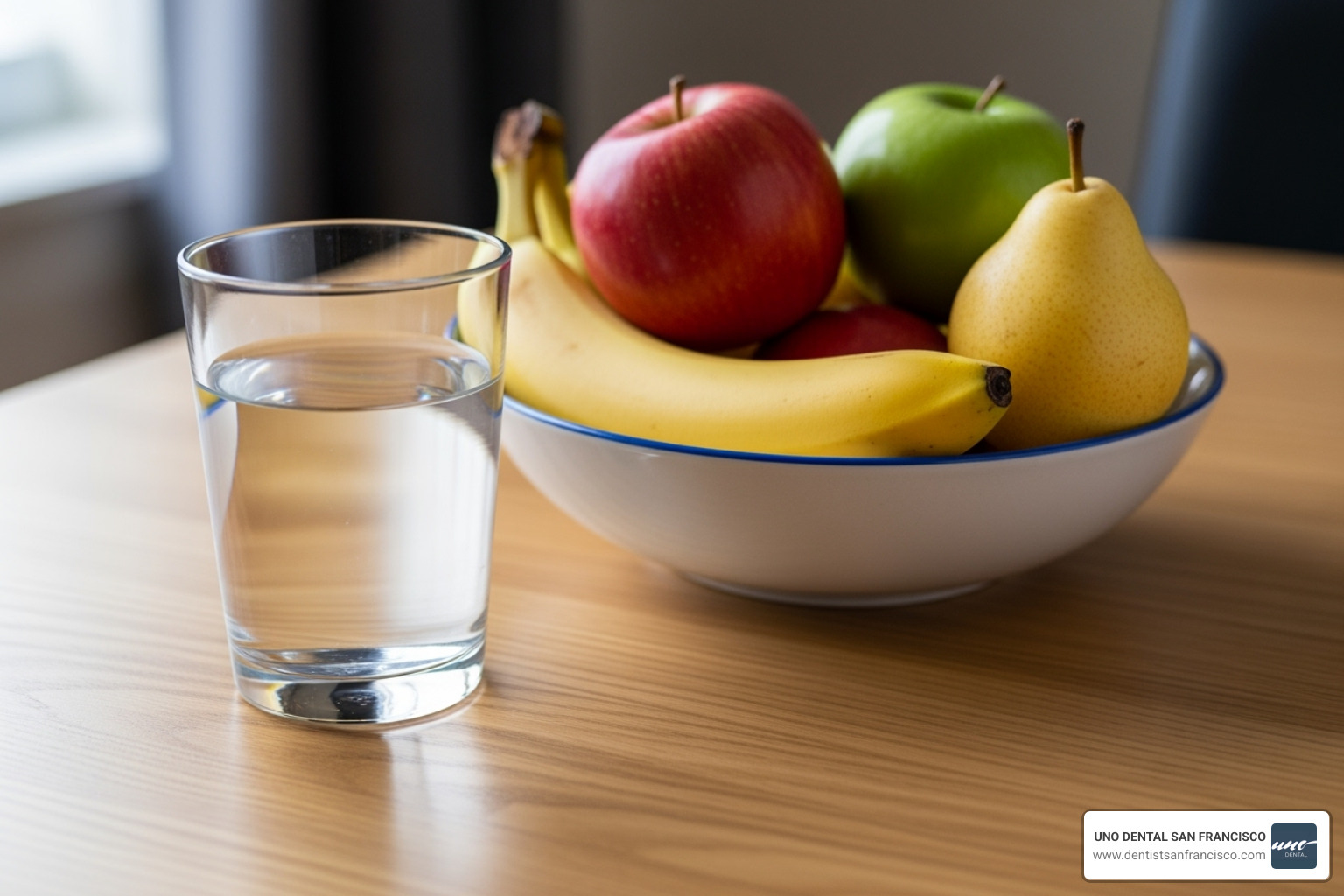 A glass of room-temperature water next to a bowl of non-acidic fruit - teeth whitening sensitivity relief A glass of room-temperature water next to a bowl of non-acidic fruit - teeth whitening sensitivity relief