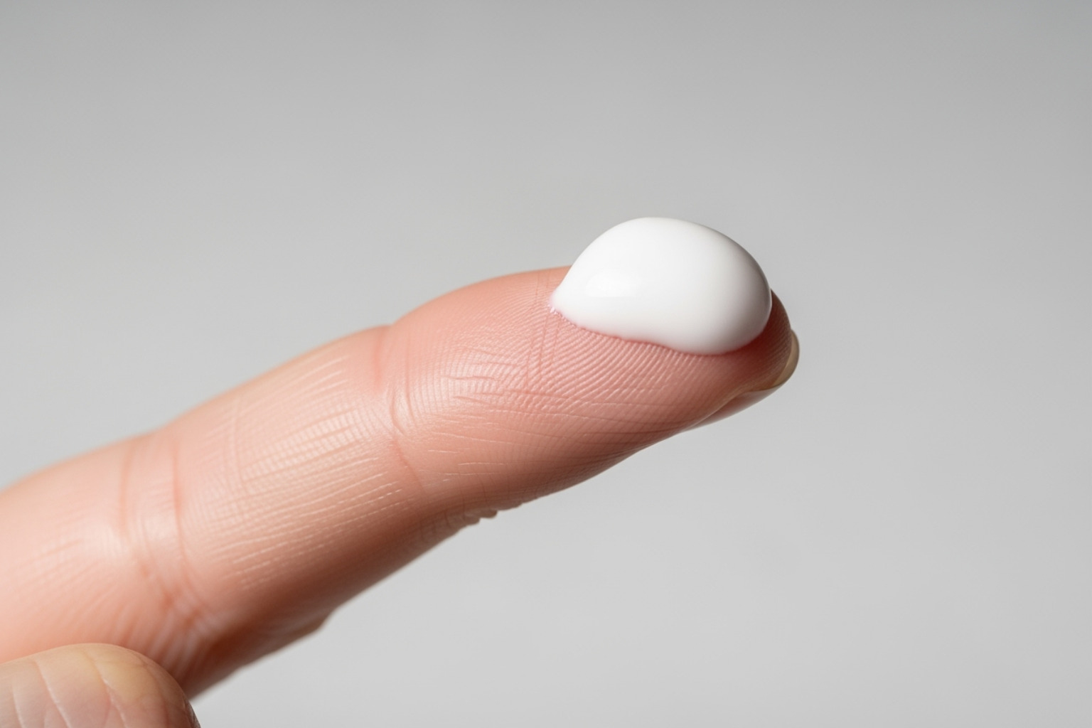 Image showing a pea-sized amount of muscle rub cream on a finger, ready for application - Muscle rub cream