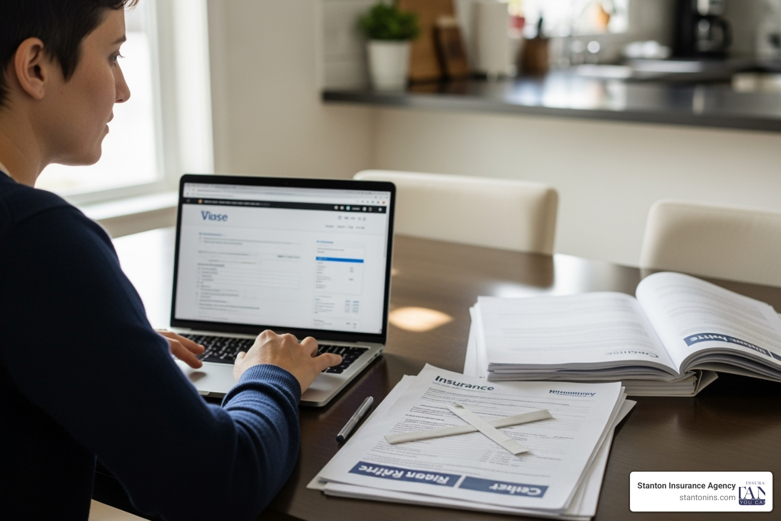 A person sitting at a kitchen table comparing insurance documents on a laptop - Auto insurance quotes MA