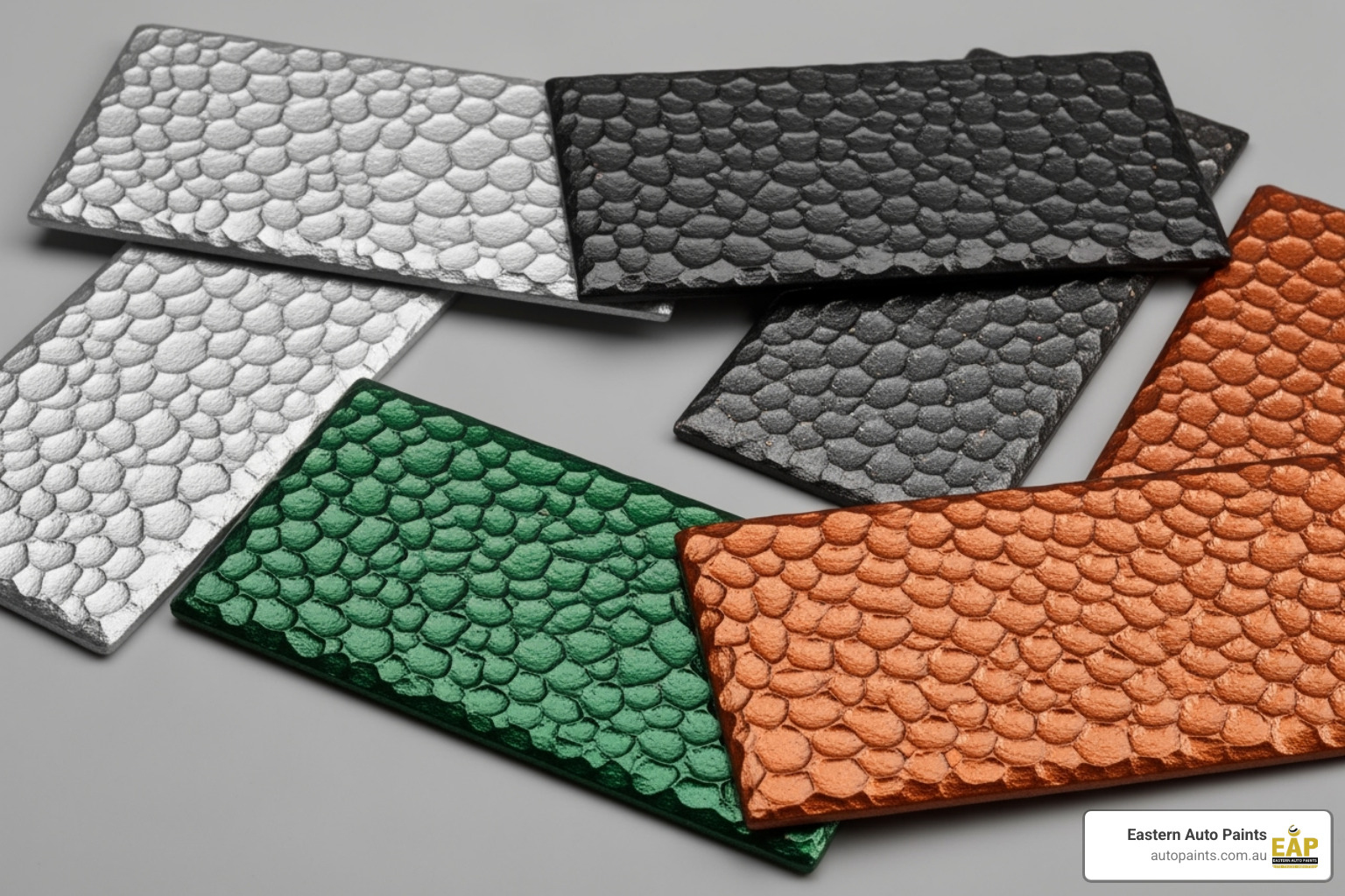 Several painted swatches showing a variety of hammertone paint colours like silver, charcoal, green, and copper - hammertone paint colours