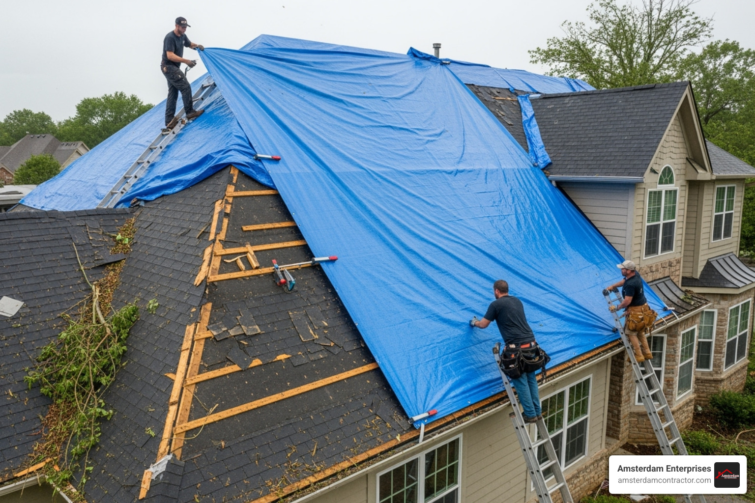 Roofers applying a large blue emergency tarp to a damaged roof section - emergency roofing company