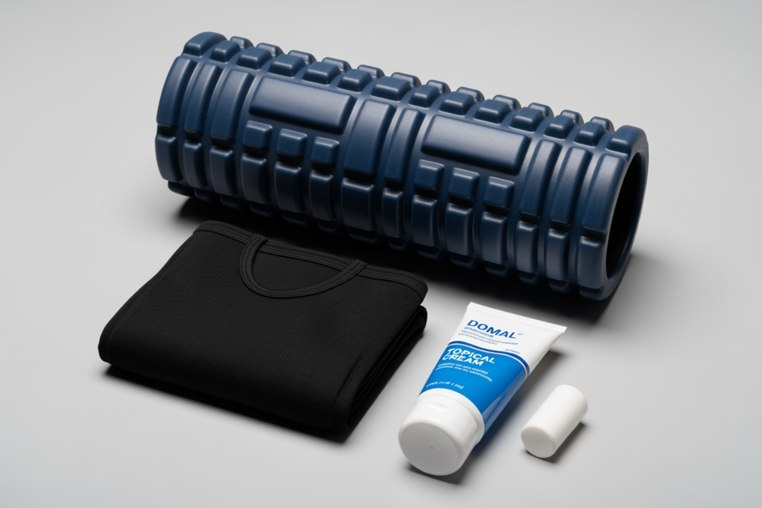 collection of DOMS relief items: a foam roller, a compression sleeve, and a topical cream - working out with doms