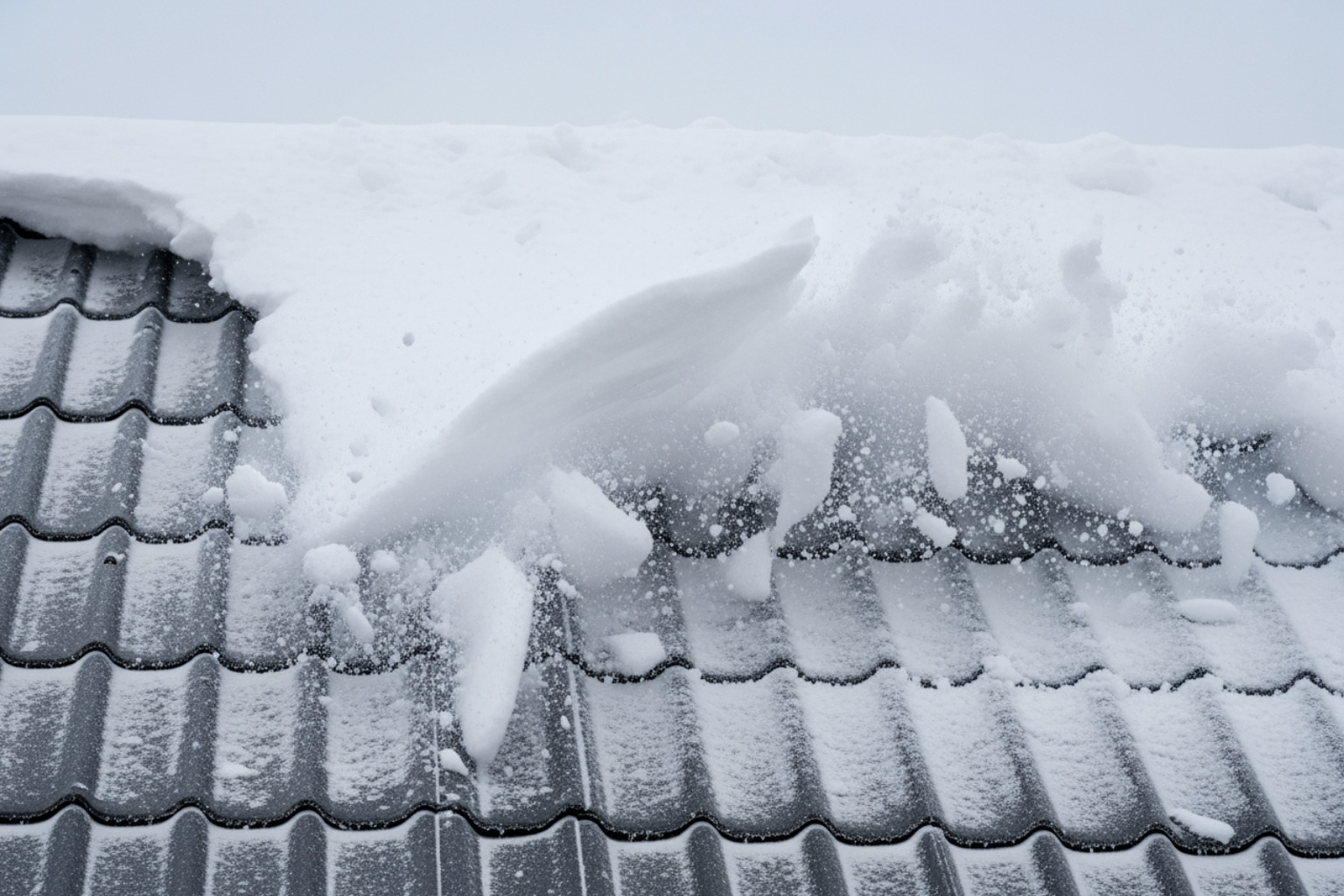 A close-up of a metal roof effectively shedding heavy snow - Metal roofing contractors Utah A close-up of a metal roof effectively shedding heavy snow - Metal roofing contractors Utah