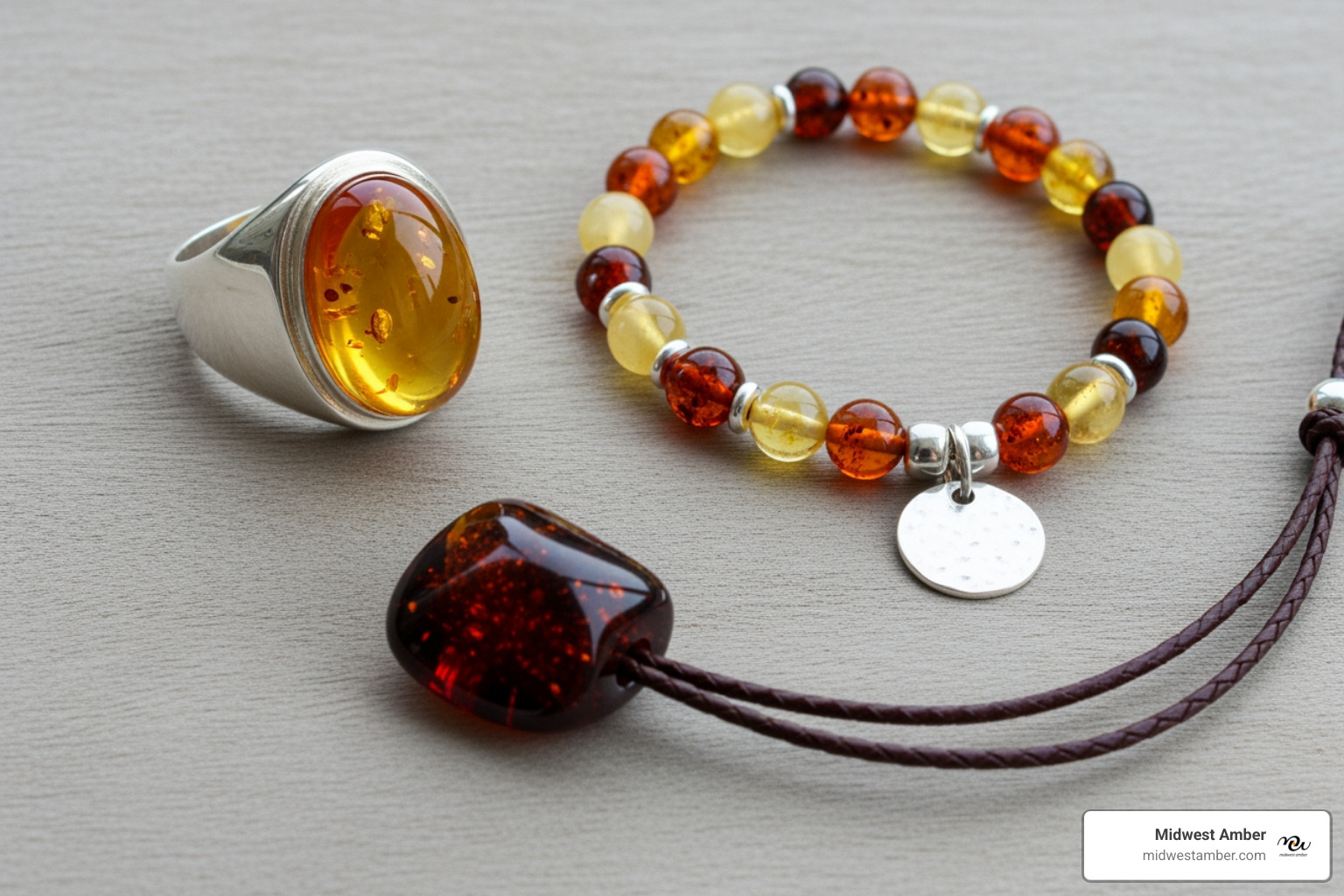 A flat lay of various men's amber jewelry pieces including a silver ring with a honey amber stone, a beaded bracelet with varied amber colors and a silver charm, and a dark amber pendant on a leather cord - Amber jewelry for men