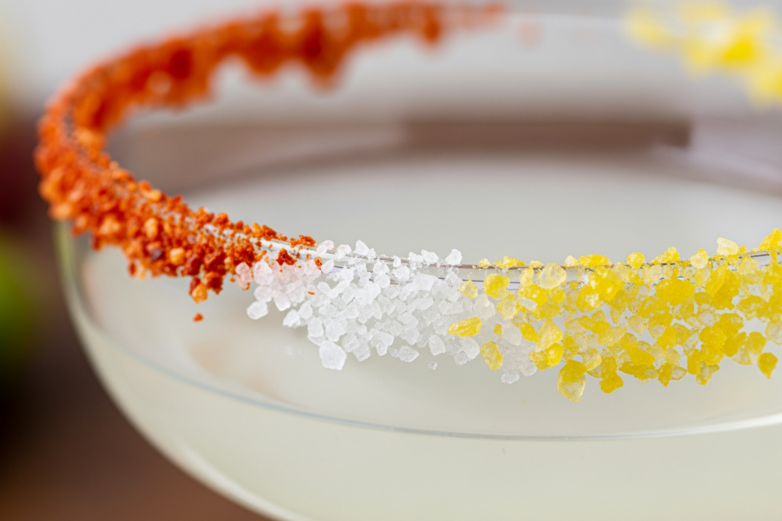 various flavored salts on a glass rim including chili salt, sea salt, and citrus salt - national margarita day various flavored salts on a glass rim including chili salt, sea salt, and citrus salt - national margarita day