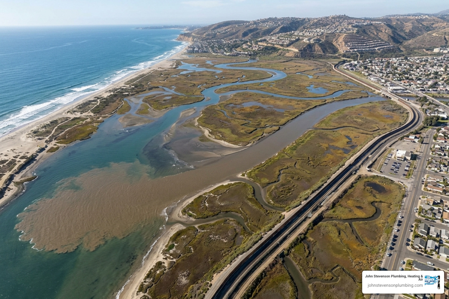 Aerial view of the Tijuana River estuary where polluted water meets the Pacific Ocean, showing visible sediment and runoff