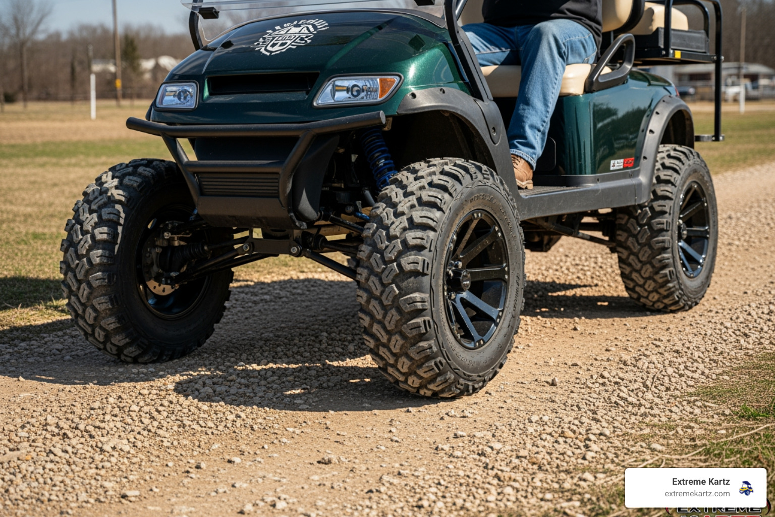 A lifted golf cart with aggressive all-terrain tires parked on a gravel trail