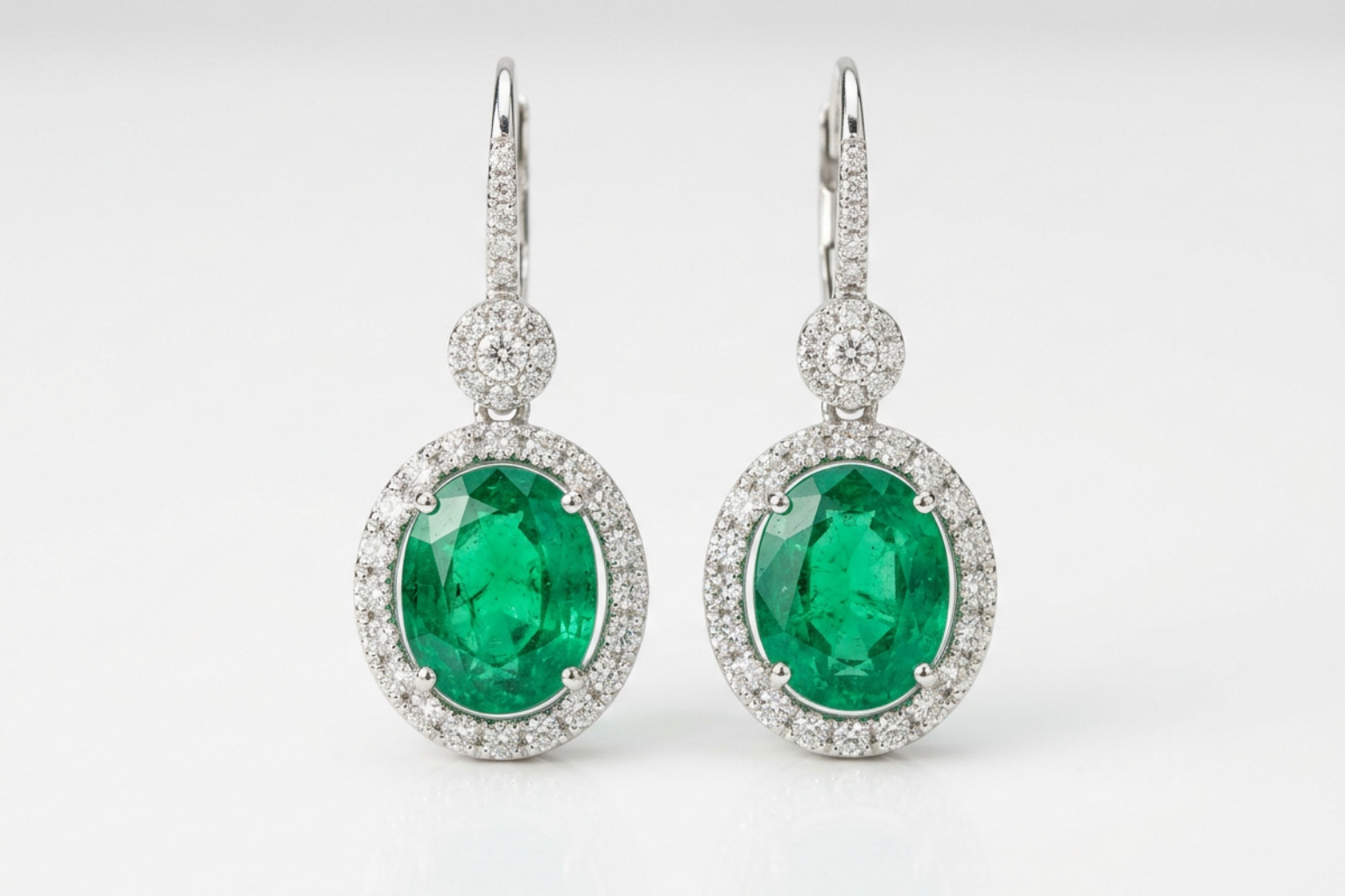 High-quality estate emerald earrings highlighting color saturation and diamond halos
