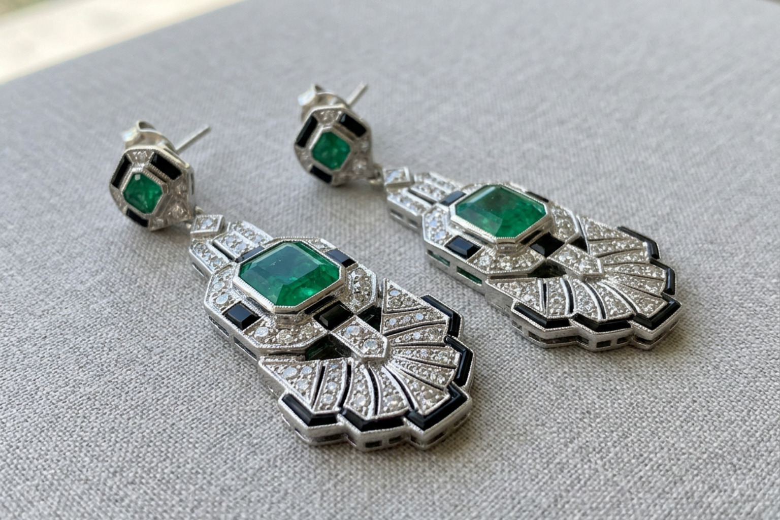 Art Deco estate emerald and diamond dangle earrings showing geometric symmetry