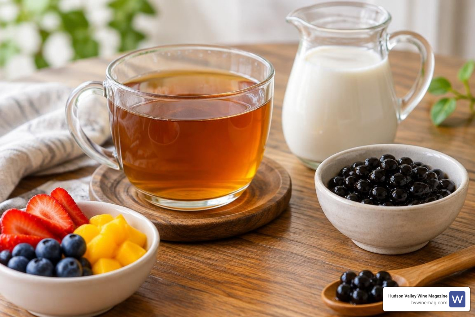 freshly brewed tea in a glass cup alongside plant-based milk and natural toppings freshly brewed tea in a glass cup alongside plant-based milk and natural toppings