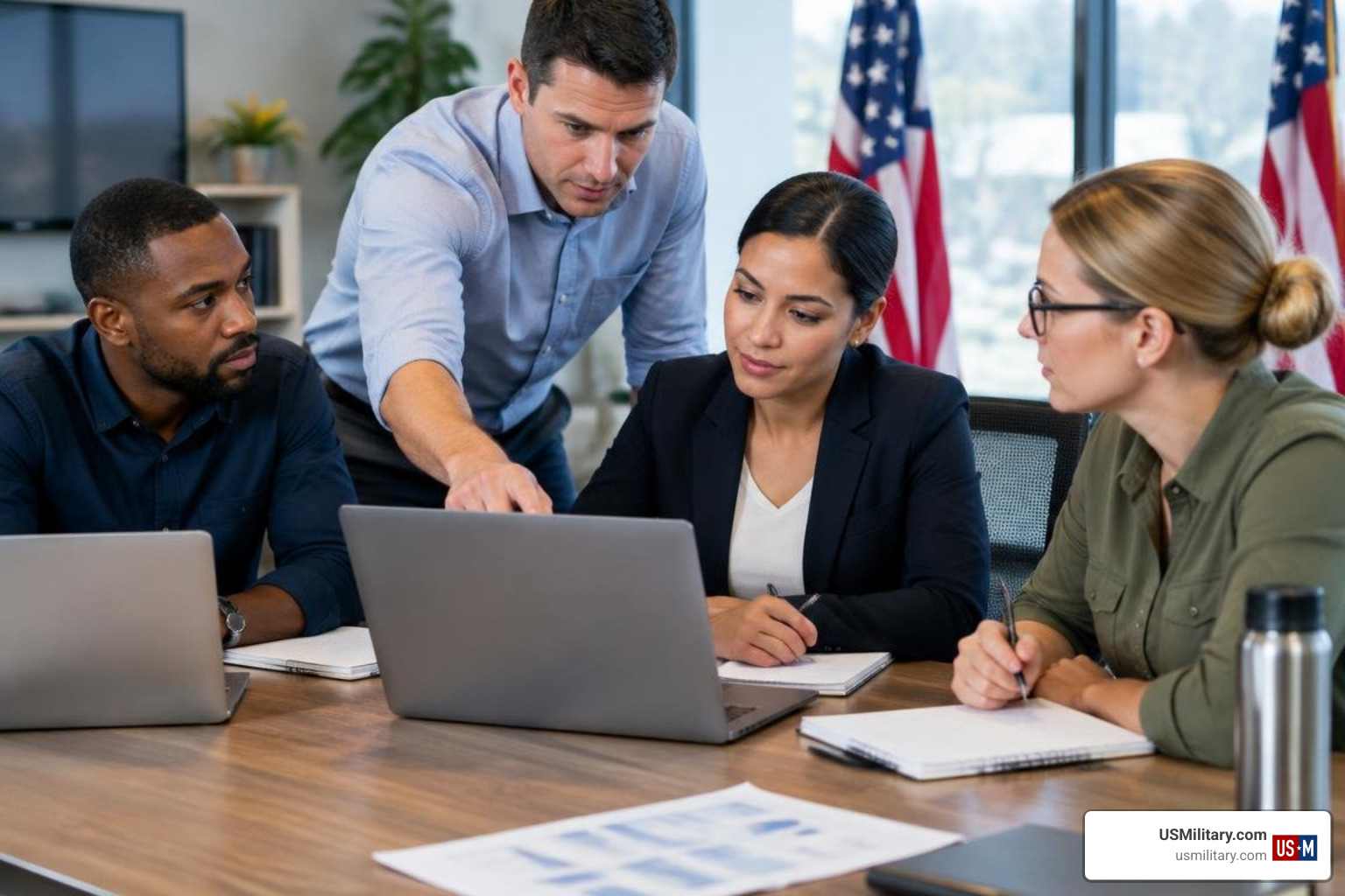 U.S. military veterans working collaboratively on a technical project in an office