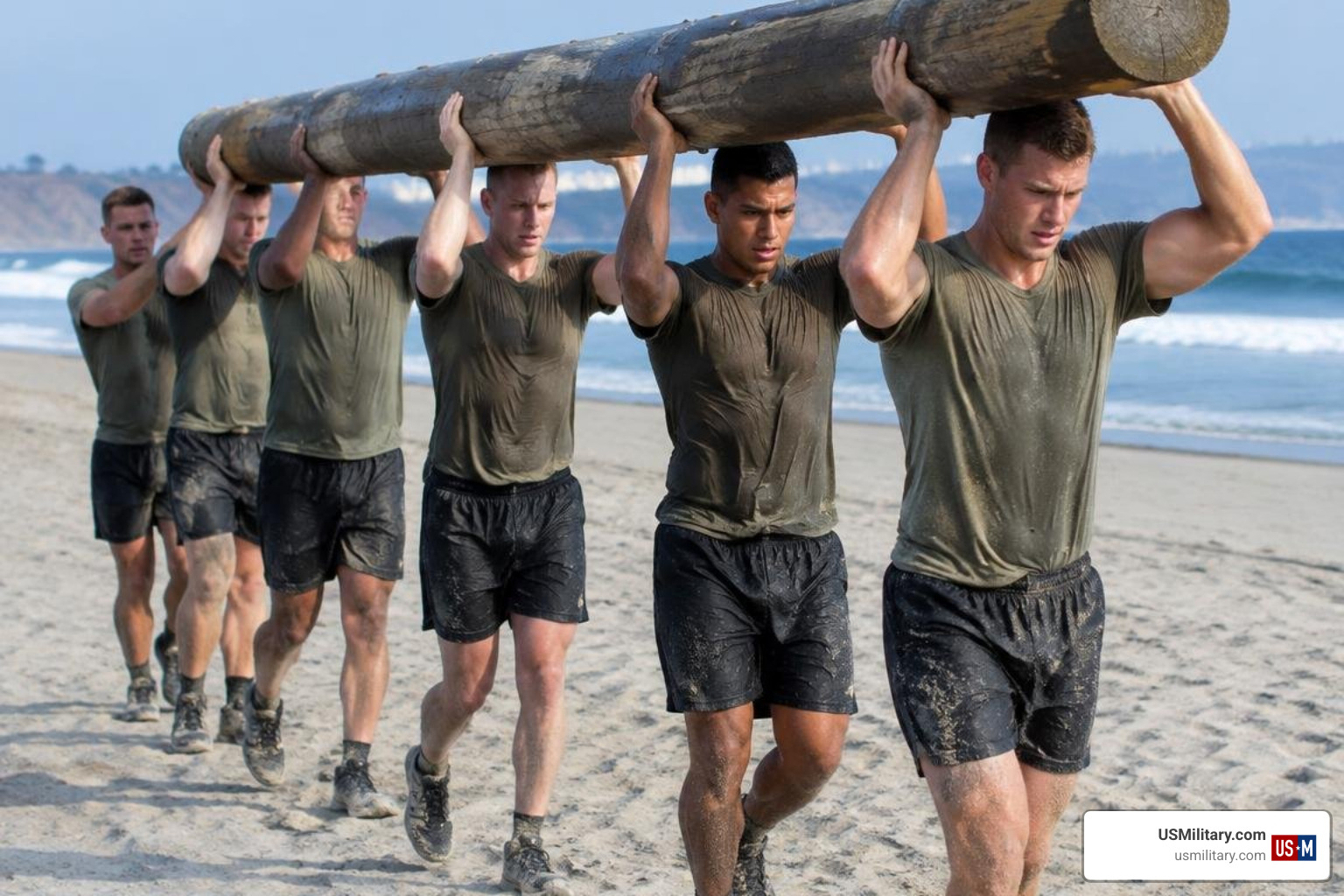 BUD/S candidates performing team log carries on the beach at Coronado